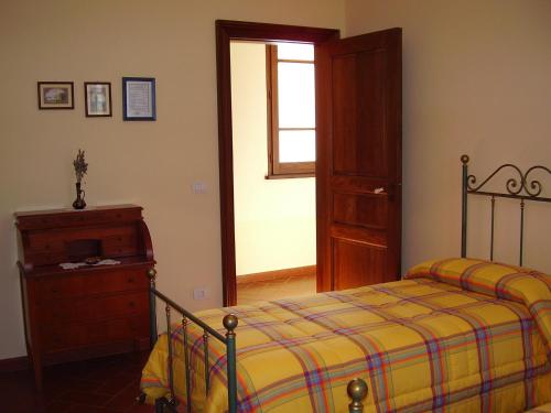 um quarto com uma cama, uma cómoda e uma janela em Agriturismo Le Carolee em Pianopoli