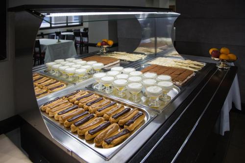 a display case filled with lots of different types of food at Hôtel National in Lourdes