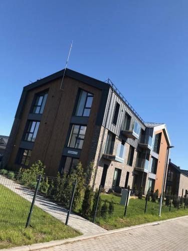ein Gebäude mit einem Zaun davor in der Unterkunft Apartment Mona in Palanga