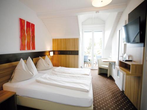 ein Schlafzimmer mit einem weißen Bett in einem Zimmer in der Unterkunft Hotel Diana in Pörtschach am Wörthersee
