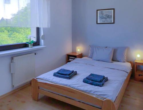 a bedroom with a bed with two towels on it at Apartamenty Łagiewniki in Krakow
