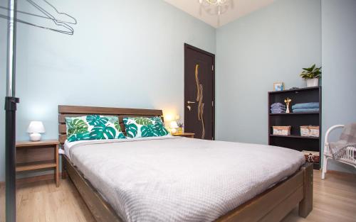 ein Schlafzimmer mit einem großen Bett mit grünen Kissen in der Unterkunft Lebu Apartment TBS in Tbilisi City