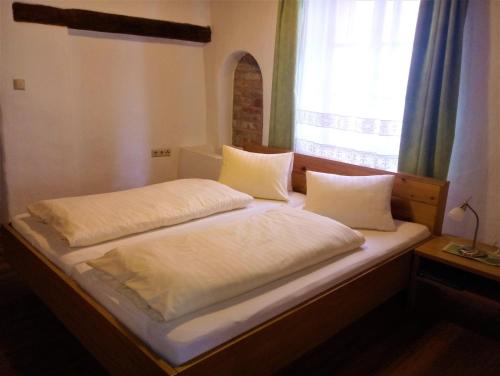 two beds sitting next to a window in a bedroom at Hotel Eisenhuthaus in Poysdorf