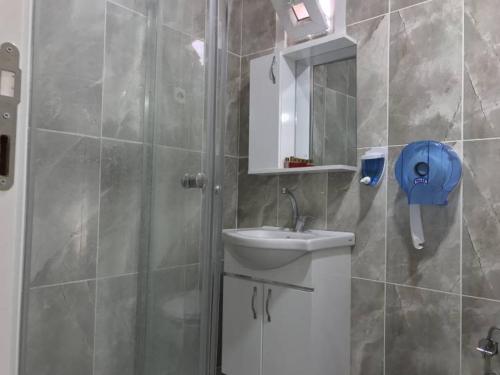 a bathroom with a shower with a sink and a mirror at NEW BEYLERBEYİ HOTEL in Istanbul