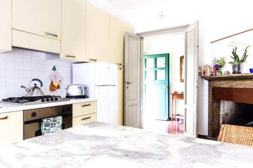 a kitchen with white cabinets and a stove top oven at Little Garden House in Cernobbio