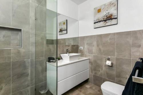 a bathroom with a sink and a toilet at BENGALEE EXECUTIVE TOWNHOUSE- MODERN & STYLISH in Mount Gambier