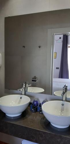 a bathroom with three sinks and a large mirror at Family Agua Amarga in Agua Amarga