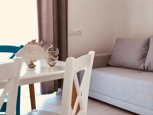 a living room with a white table and a couch at Kolory Lata - 365PAM KLIMATYZACJA I PLAC ZABAW W OBIEKCIE in Sarbinowo