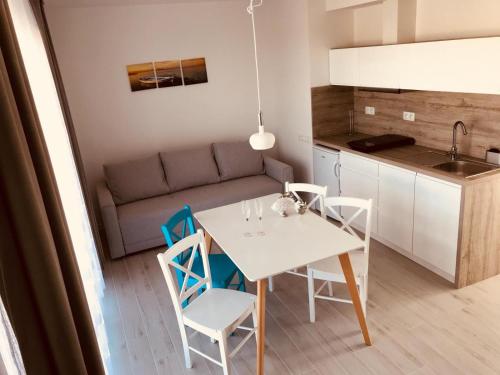 a kitchen and a table and chairs in a room at Kolory Lata - 365PAM KLIMATYZACJA I PLAC ZABAW W OBIEKCIE in Sarbinowo