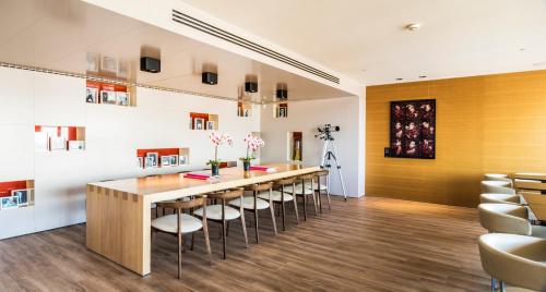 a dining room with a long table and stools at The Hotel Brussels in Brussels