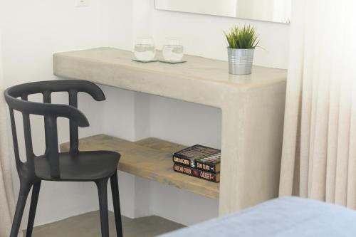 a desk with a chair and a table with glasses at Cova Mykonos Suites in Elia Beach