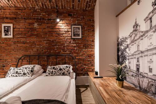 a room with two beds and a brick wall at DIETLA 99 APARTMENTS - IDEAL LOCATION - in the heart of Krakow in Kraków