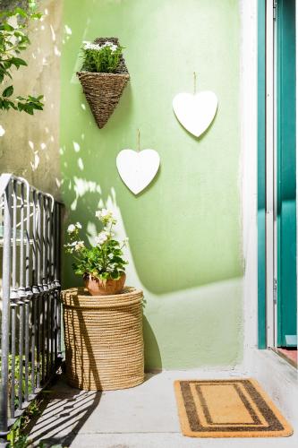 two hearts hanging on a wall with a plant at Little Garden House in Cernobbio