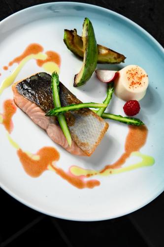 a plate of food with a piece of fish and vegetables at Mediterranean Palace in Thessaloniki