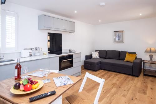 a kitchen and living room with a table and a couch at Weeping Willow – Three Tuns Apartments, Pettistree in Pettistree