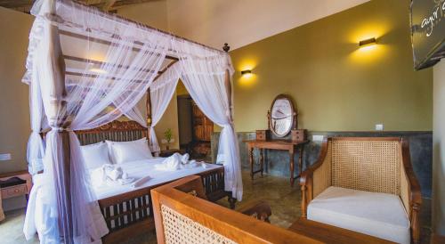 a bedroom with a canopy bed and a chair at Ayur Ayur Resort & Ayurveda Retreat in Negombo