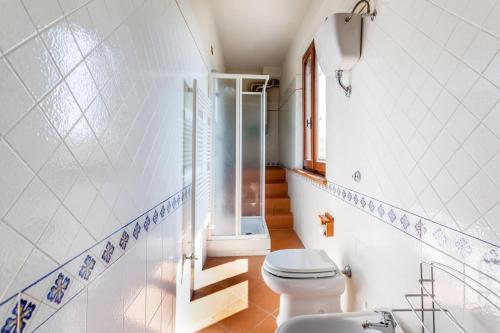 a bathroom with a toilet and a sink and stairs at Poggio Vaccaio Casa Tramonto in Binami