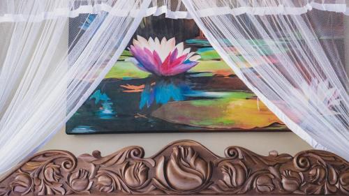 a painting of a flower on a wall with curtains at Ayur Ayur Resort & Ayurveda Retreat in Negombo