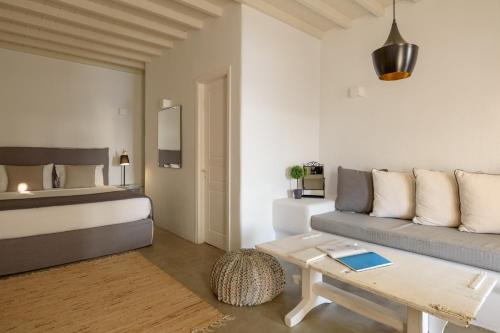 a living room with a bed and a couch at Cova Mykonos Suites in Elia Beach