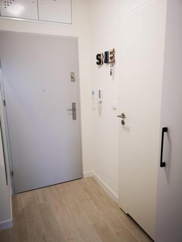 a white room with a white door and a wooden floor at Aquamarina Onyx Seaside in Międzyzdroje