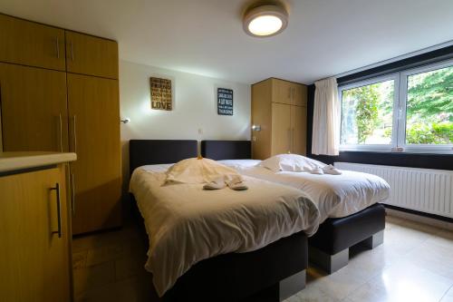 a bedroom with a large bed with towels on it at Hotel Pracha in Borgloon