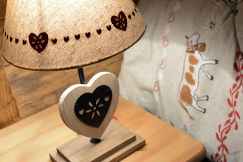 a lamp with a heart on a wooden table at Vieilles Maisons D'Introd in Introd