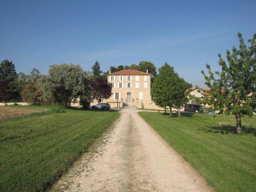 a dirt road in front of a large house at Maison Saint-Pé (Gers) in Béraut