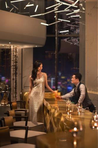 a man and a woman standing at a bar at Raffles Shenzhen, Situated in the heart of One Shenzhen Bay, Book Now to Enjoy Free Minibar and Happy Hour Privileges at Long Bar on 71F in Shenzhen