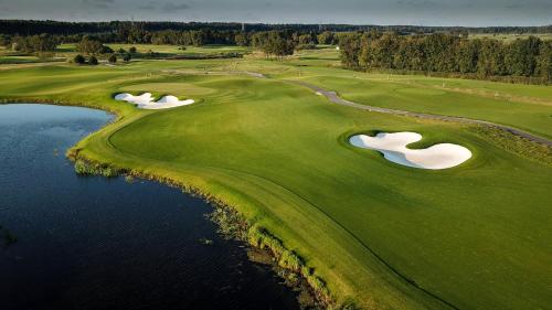 an aerial view of a golf course with two putting greens and water at Jurmala Golf Club&Hotel in Piņķi