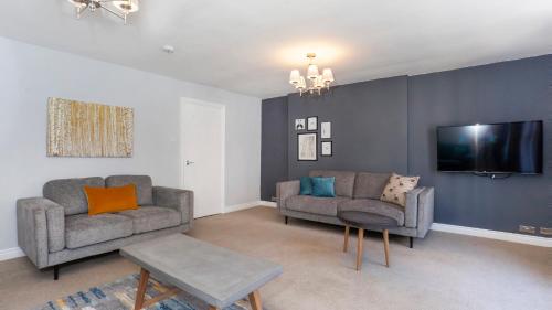 a living room with two couches and a tv at Malt Shovel Court with Free Parking in York