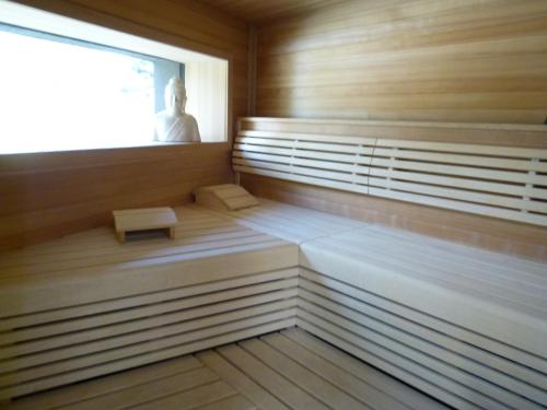 a sauna with a man sitting in the window at Hotel Landhaus Moserhof in Gumpoldskirchen