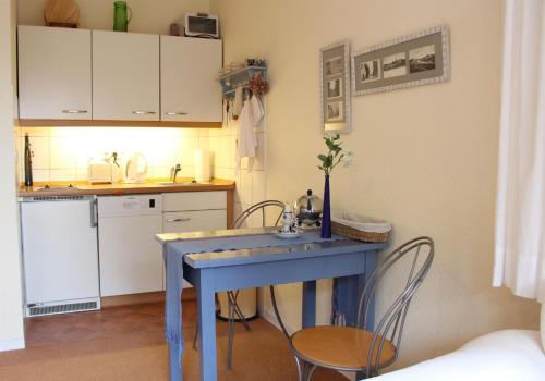 una cucina con tavolo blu e 2 sedie di Fritz-Wischer-Straße 7, Whg. Behr, Nr. 4 a Sankt Peter-Ording