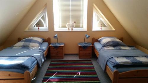 two beds in a room with two windows at Ferienwohnungen Meeresgruss in Sankt Peter-Ording