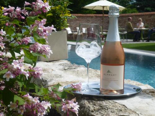 a bottle of wine and a glass next to a pool at Hotel Landhaus Moserhof in Gumpoldskirchen
