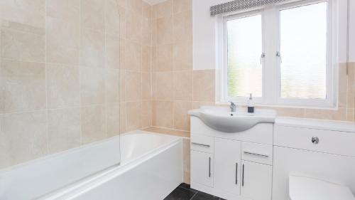 a bathroom with a white sink and a bath tub at Malt Shovel Court with Free Parking in York