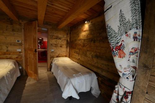 a room with two beds in a log cabin at Vieilles Maisons D'Introd in Introd
