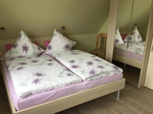 a bed with purple and white sheets and pillows at Haus Fabricius in Tating