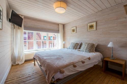 een slaapkamer met een bed en een groot raam bij Maison Mariette in Nieuwpoort