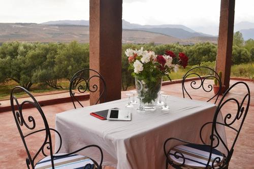 a table with a vase of flowers on a porch at Villa Paradise in Aghmat