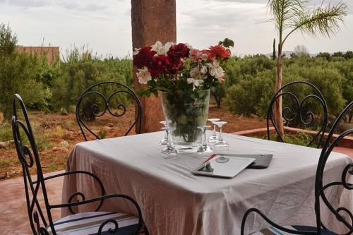 a table with a vase of flowers on it at Villa Paradise in Aghmat