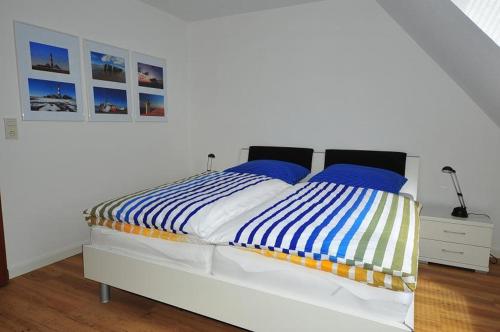 a bedroom with a bed with blue and white sheets at Juteshus in Tating
