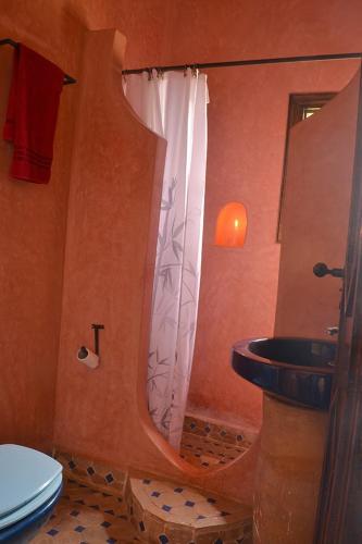 a bathroom with a shower with a sink and a toilet at Villa Paradise in Aghmat