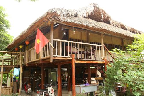 a house with a flag in front of it at Dong Que Homestay-Tours-Motorbike, Car rental, Hiking in Ha Giang