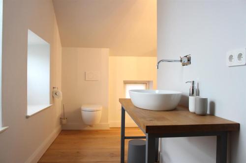 ein Badezimmer mit einem weißen Waschbecken auf einer Holztheke in der Unterkunft Ferienhäuser SPO in Sankt Peter-Ording