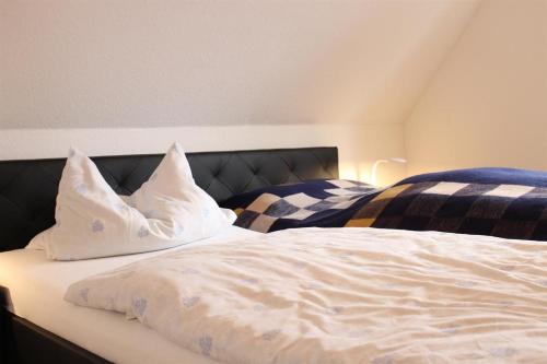 a bed with two pillows on top of it at Haus Kastanie in Sankt Peter-Ording