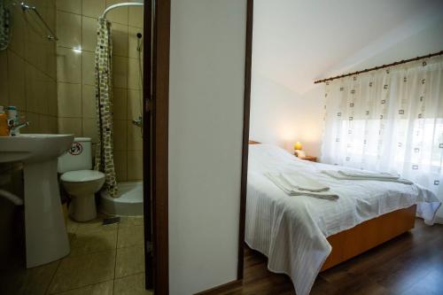 a bedroom with a bed and a bathroom with a sink at Casa Matei in Mahmudia