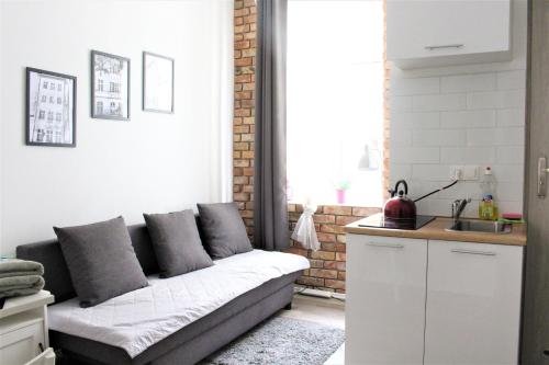 a living room with a couch and a kitchen at Stay99 Apart in Poznań