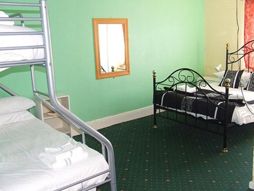 a room with two bunk beds and a mirror at The Woodfield Hotel , Indoor Heated swimming pool, Spacious lounge and Bar in Blackpool