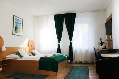 um quarto com uma cama com um cobertor verde em Hotel Na Pekárně em Sušice