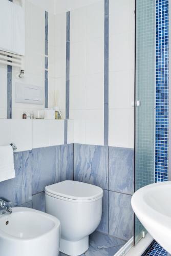 a white bathroom with a toilet and a sink at Fiorentini Residence NAPOLI in Naples